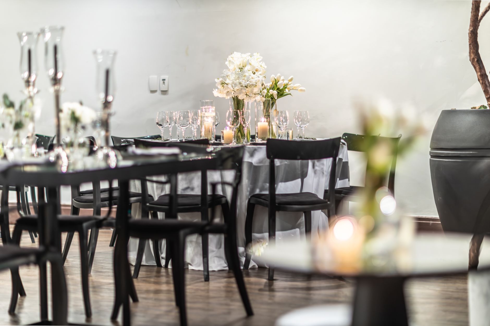 A beautifully arranged wedding reception table featuring candles and flowers, creating a warm and intimate atmosphere. — Is I
